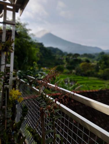 a fence with a view of a mountain at Uthe house in Pacet