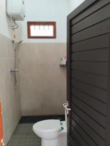 a bathroom with a toilet and a door at Uthe house in Pacet