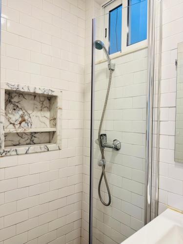 a shower with a glass door in a bathroom at Travessa do Meio Apartment in Lisbon