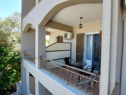 a balcony of a house with a table and chairs at Araxovoli Studios - Aραξοβόλι Lefkada in Tsoukalades
