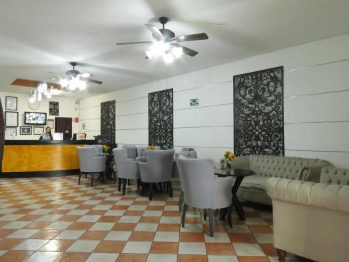 a restaurant with chairs and a table and a bar at Hotel Los Girasoles in Tepic