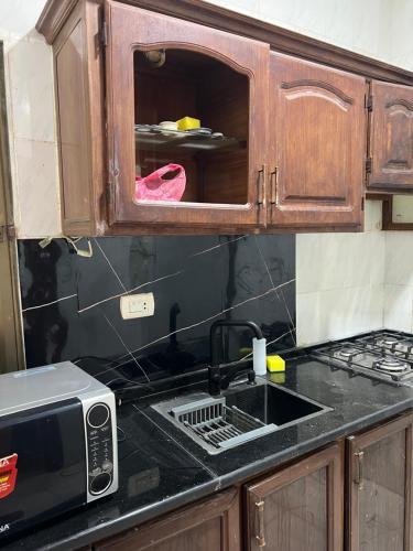 a kitchen with a sink and a microwave at الراقي in Amman