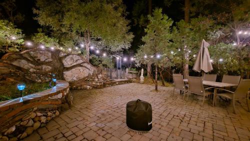 Un patio con mesa, sillas y luces. en Bass Lake Cabin-Pet Friendly, en Bass Lake