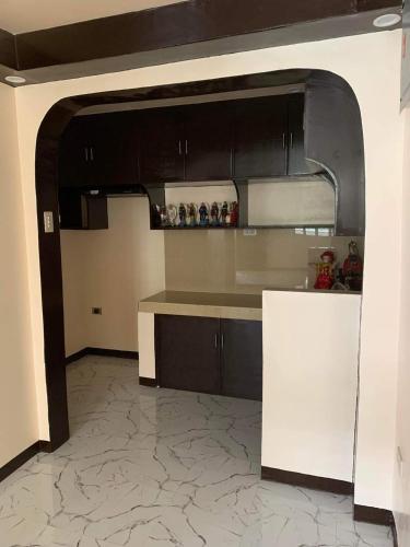 a kitchen with black cabinets and a white counter top at Balili Property in Amitty Ville