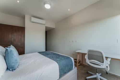 a bedroom with a bed and a desk and a chair at Depto de Lujo frente al Mar in San Bruno