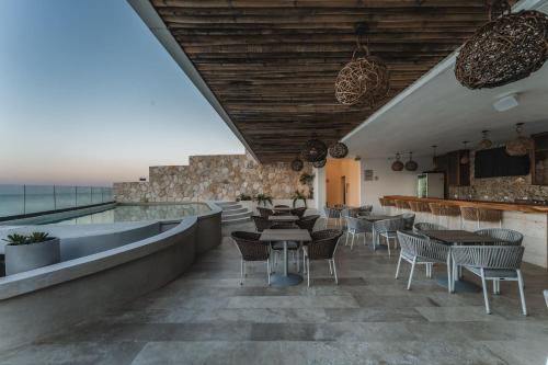 a restaurant with tables and chairs and a view of the ocean at Depto de Lujo frente al Mar in San Bruno