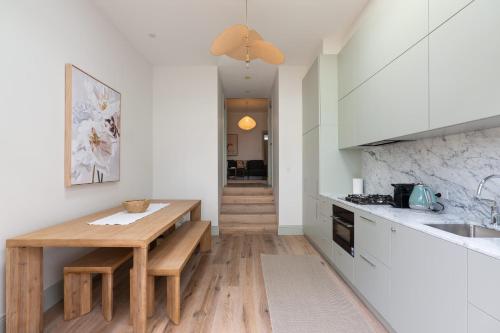 a kitchen with a wooden table and a counter at Exquisite Modern 3 Bed Home in Newtown w Parking in Sydney