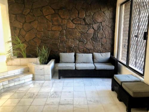 a patio with a couch and a stone wall at Casa La Embajada in La Paz