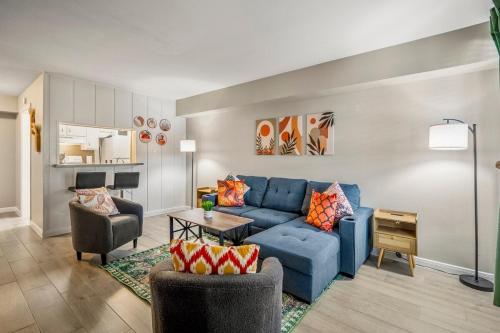a living room with a blue couch and chairs at Towne Plaza Apartments 111 - 7 km from FIFA Fest in Houston
