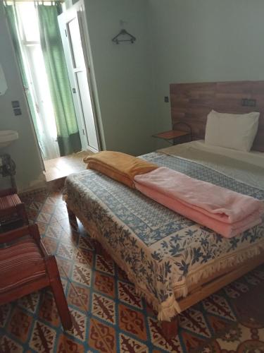 a bedroom with two twin beds and a rug at Hôtel des cèdres azrou province ifrane in Azrou