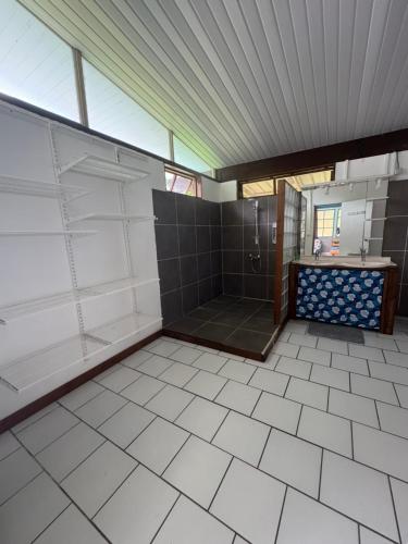 a bathroom with a shower and a tiled floor at Blue Moana Lodge in Papara