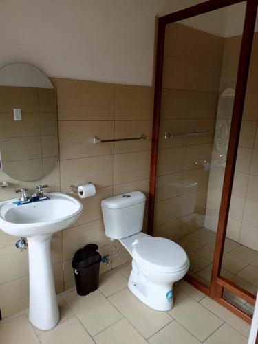 a bathroom with a toilet and a sink at Hostal Casa Alamos in Guaranda