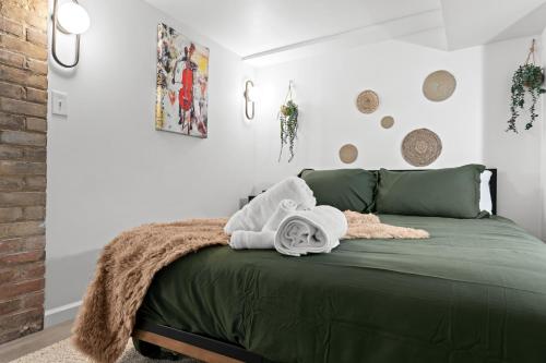 a bedroom with a green bed with towels on it at The Chill Cellar in Detroit