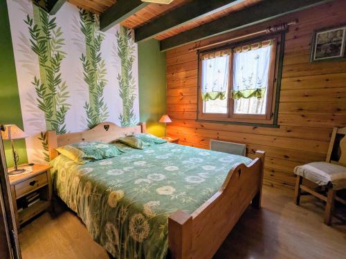 a bedroom with a bed and a wooden wall at Chalet confortable avec 4 chambres, cheminée, grand terrain, proche pistes et lac - FR-1-589-107 in Le Ménil
