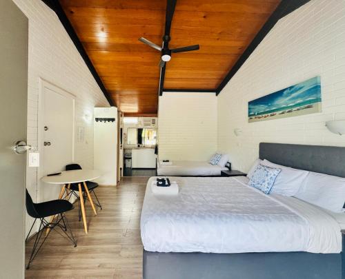 a bedroom with a large bed with a wooden ceiling at Jetty Motel The Entrance in The Entrance
