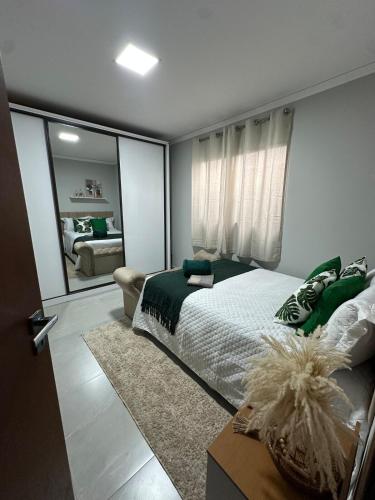 a bedroom with a large bed and a mirror at Sinta-se em Casa in Cornélio Procópio