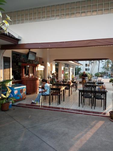 a woman sitting at a restaurant with tables and chairs at View Talay 1B by Fernando in Pattaya South
