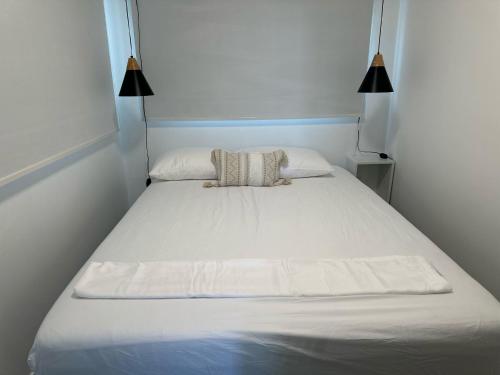 a large white bed in a room with two lamps at The Hangover Block in Culebra