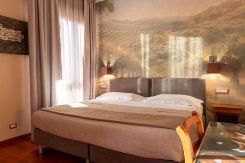 a bedroom with a bed with a painting on the wall at Hotel Terme Salvarola in Sassuolo