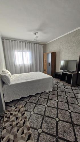 a bedroom with a bed and a flat screen tv at Lindos sobrado aconchegante próximo ao aeroporto de Guarulhos Ponte Alta! in Guarulhos