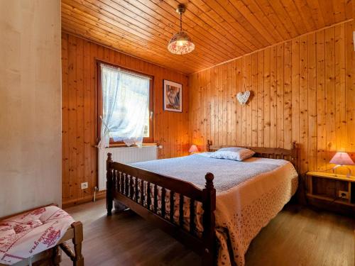 une chambre avec un lit dans une pièce en bois dans l'établissement Chalet familial à La Bresse, proche randonnées, WIFI, animaux admis - FR-1-589-425, à La Bresse