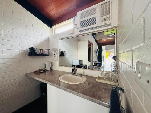 a bathroom with a sink and a mirror at Jetty Motel The Entrance in The Entrance