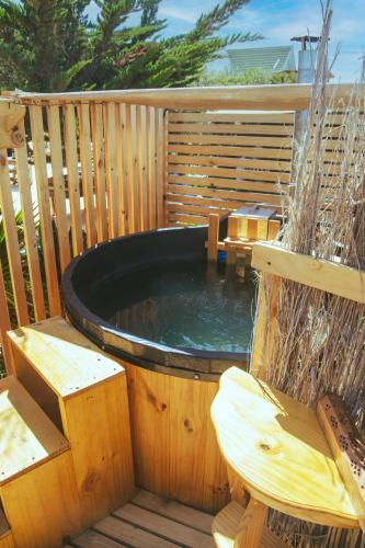 a hot tub on a wooden deck with two benches at Aldea Bahiguana Piso Privado 5 personas in Bahia Inglesa