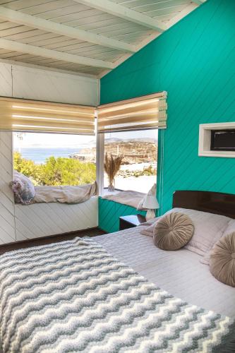 a bedroom with two beds and a large window at Aldea Bahiguana Piso Privado 5 personas in Bahia Inglesa