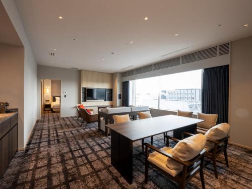 a living room with a table and chairs at ANA Crowne Plaza Akita by IHG in Akita