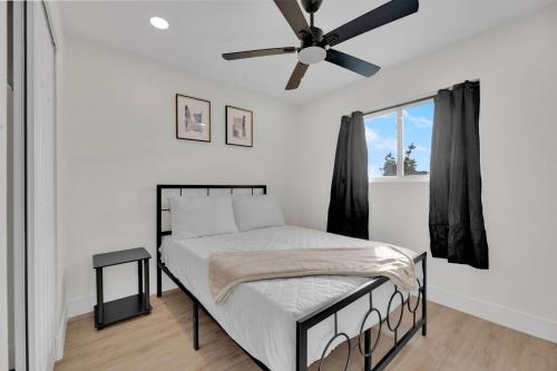 ein Schlafzimmer mit einem Bett mit Deckenventilator in der Unterkunft Modern 4BR3Ba Home with Pool and Fire Pit in Phoenix