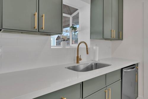 eine weiße Küche mit Spüle und Fenster in der Unterkunft Modern 4BR3Ba Home with Pool and Fire Pit in Phoenix