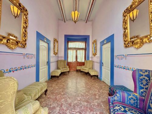 a waiting room with chairs and mirrors on the walls at Hotel La Alhondiga in Puebla