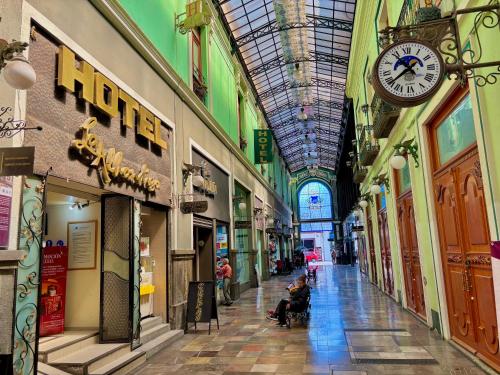 a shopping mall with a clock on the ceiling at Hotel La Alhondiga in Puebla