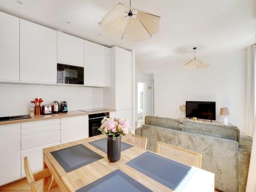 une cuisine et un salon avec une table et un canapé dans l'établissement Cosy & Modern Apartment - 1BR 4P - Montreuil, à Montreuil