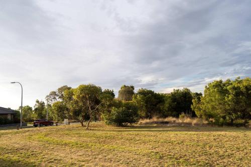 a car parked in a field with trees and a street light at Modern 3B2B1C Home in Doreen in Doreen