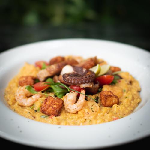 a white bowl of food with shrimp and vegetables at Hotel Baluarte Cartagena Boutique in Cartagena de Indias