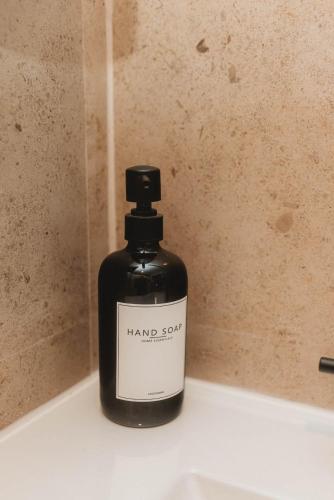 a bottle of hand soap sitting on top of a sink at Cozy Miami Suite with FREE Parking in Miami