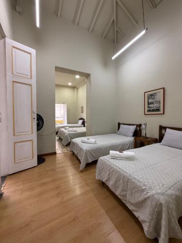 a room with three beds and a door in it at Del Rocío Alojamiento -ANDES in Los Andes
