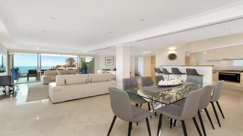 a dining room and living room with a table and chairs at Unit 51 - 4 Bed Premier Ocean View in Terrigal