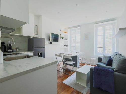 une cuisine et un salon avec un canapé et une table dans l'établissement Charming apartment-1BR-3P-Ternes, à Paris