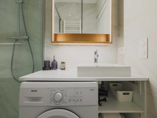 une salle de bain avec un lavabo et une machine à laver dans l'établissement Charming apartment-1BR-3P-Ternes, à Paris