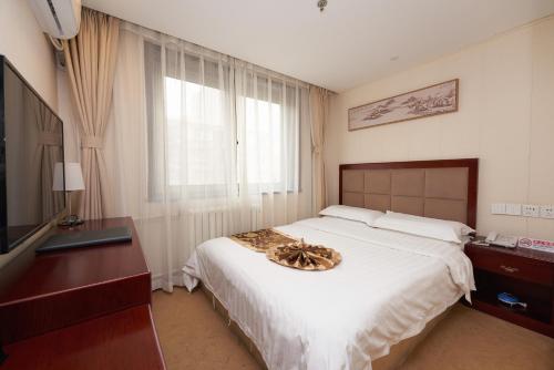 une chambre avec un grand lit et une télévision dans l'établissement 东方凯旋酒店北京南站店, à Pékin