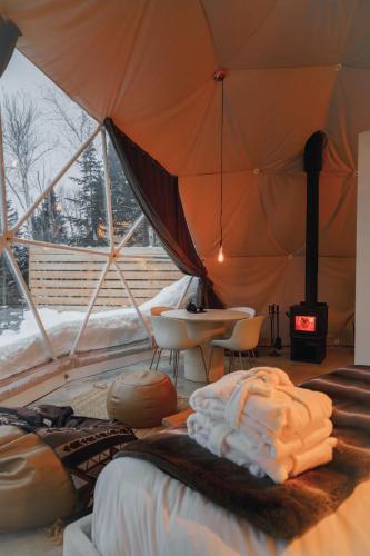Habitación con tienda de campaña, cama y chimenea en Nørdika Charlevoix, en Baie-Saint-Paul