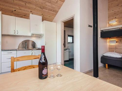 a bottle of wine sitting on a table with two wine glasses at 5 person relaxing holiday park home in Rønde in Rønde