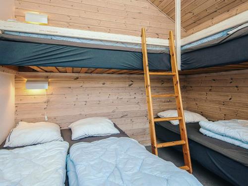 a room with two bunk beds and a ladder at 5 person relaxing holiday park home in Rønde in Rønde
