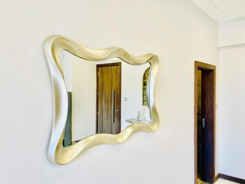 a mirror hanging on a wall with a sink at Skynest Residences Nairobi, Westlands in Nairobi