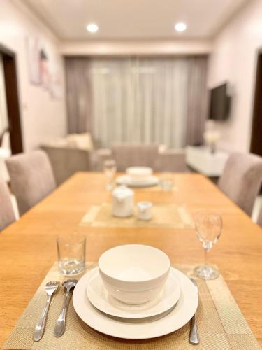 a wooden table with plates and silverware on it at Skynest Residences Nairobi, Westlands in Nairobi