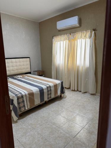 a bedroom with a bed and a window with curtains at NEKZA TEMPORARIOSs in Resistencia