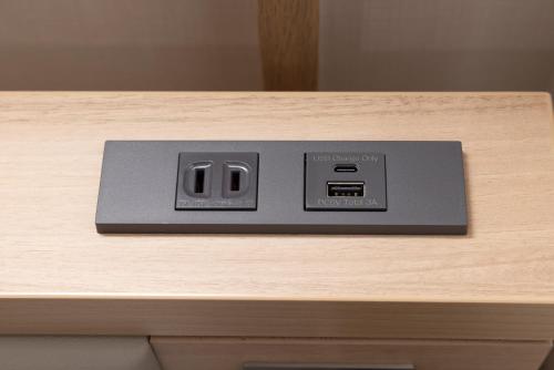 a digital clock sitting on top of a wooden table at Hotel Cerezo in Tokyo