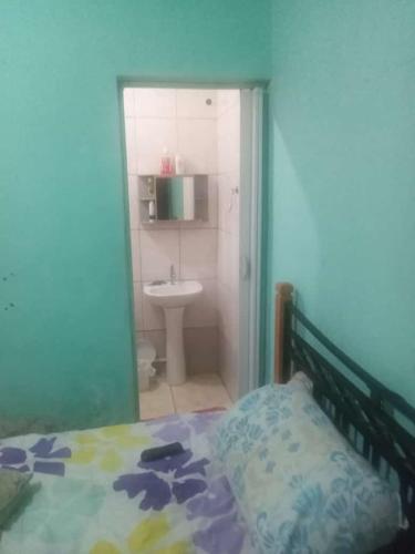 a bedroom with a bed and a bathroom with a sink at Mongaguá, AGENOR de Campos, PRAIA in Mongaguá